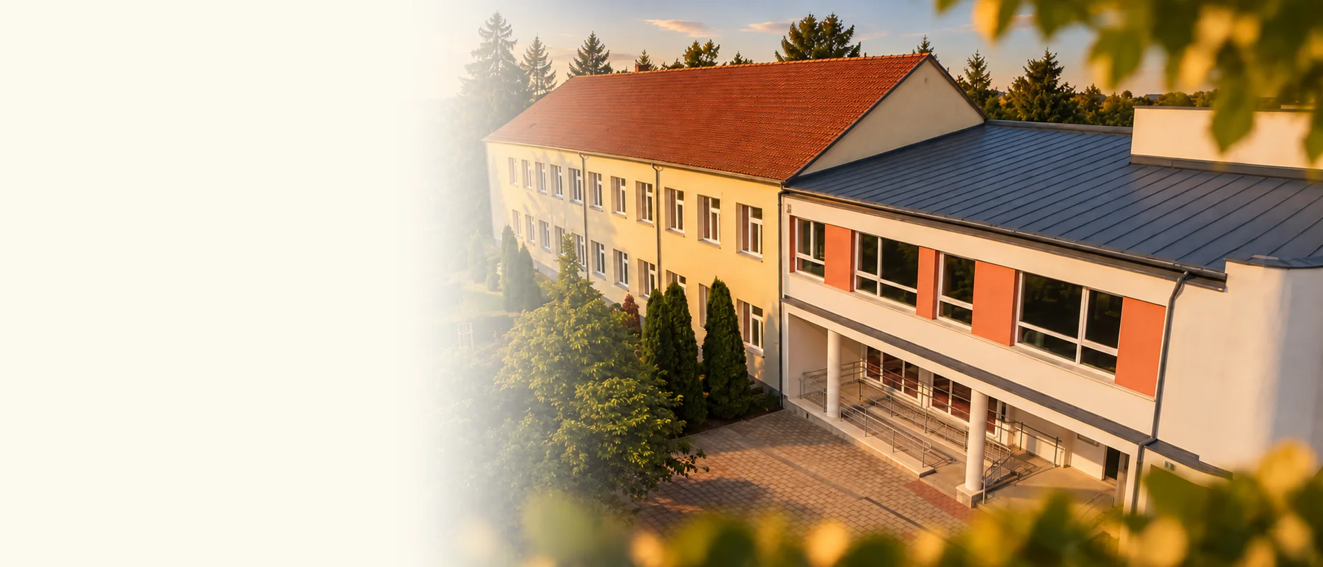 A Hatosiskola épülete és udvara, fákkal ölelt környezetben